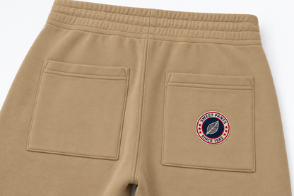 Détail du molleton beige Sweet Pants Iconic Straight, poche arrière, coutures et patch logo brodé.