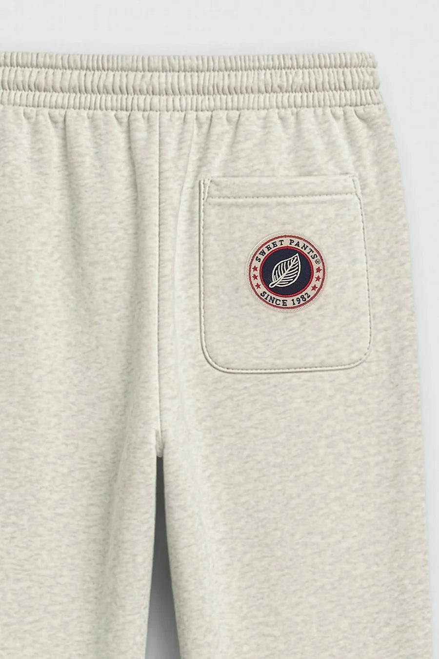Détail du patch logo tricolore Sweet Pants sur la poche arrière du jogging Iconic Straight