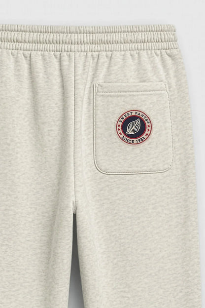 Détail du patch logo tricolore Sweet Pants sur la poche arrière du jogging Iconic Straight
