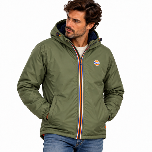 Homme portant une parka Gulf kaki à capuche doublée bleu marine, fermeture zippée tricolore et logo Gulf sur la poitrine, sur fond blanc studio.